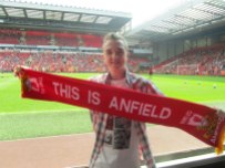 I hold up a 'This is Anfield' scarf at pitchside